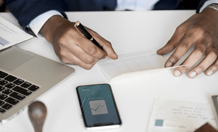 A view of hands signing a paper